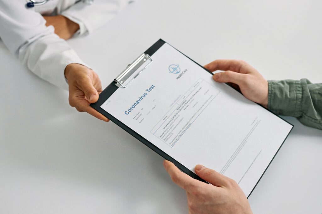 A doctor hands over coronavirus test results to a patient during a consultation in a medical clinic.
